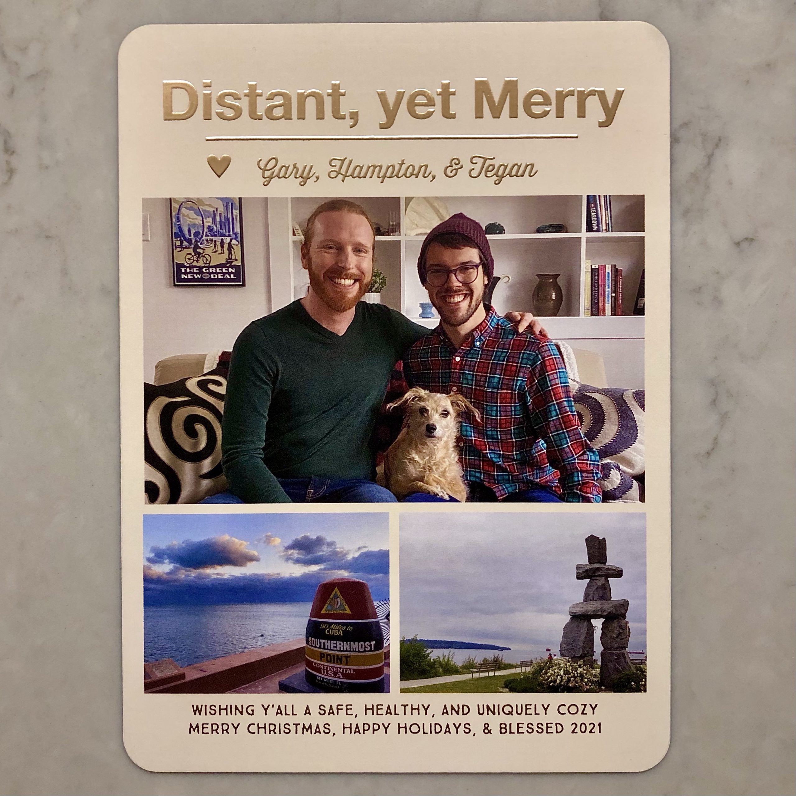 Front of card.
Distant, yet Merry
<3 Gary, Hampton, & Tegan
[Photo: Hampton, Tegan, and Gary smiling on the couch in our apartment.]
[Photo diptych: L, the marker of the Southernmost Point in the Continental USA in Key West, FL, with the Caribbean Sea behind it; R, the Ilanaaq Inukshuk at English Bay Beach in Vancouver, BC, with Kitsilano and the Pacific Ocean behind it.]
Wishing y'all a safe, healthy, and uniquely cosy Merry Christmas, Happy Holidays, & Blessed 2021